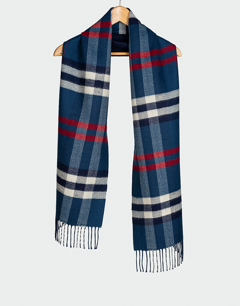Bufanda a cuadros en azul marino con líneas rojas y blancas flecos finos colgada en gancho de madera estilo clásico de invierno