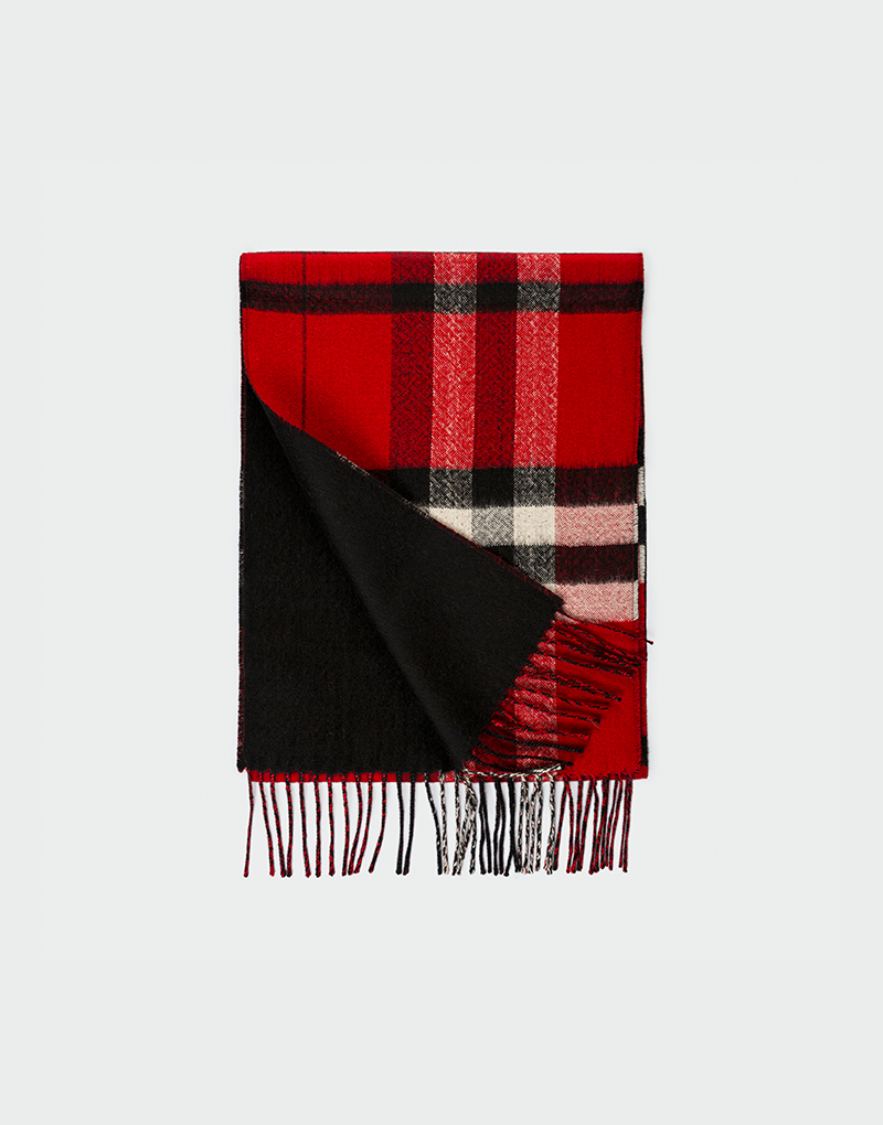 Bufanda a cuadros rojos negros y blancos doblada con detalle del reverso en negro liso y terminación en flecos